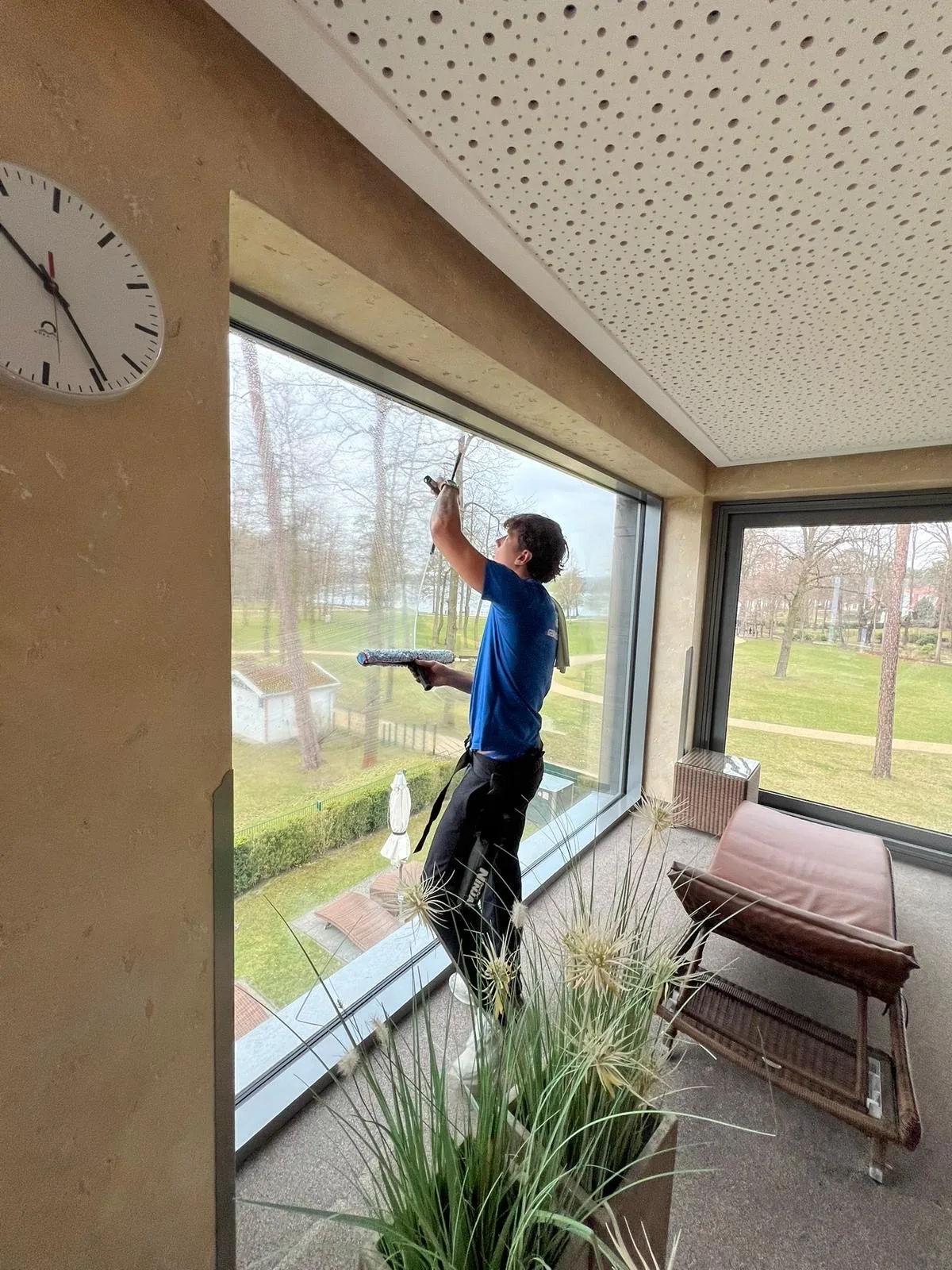 Fensterreinigung von innen an einem Panoramafenster